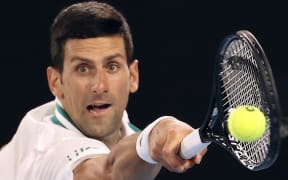 (FILES) In this file photo taken on February 21, 2021, Serbia's Novak Djokovic hits a return against Russia's Daniil Medvedev during their men's singles final match on day fourteen of the Australian Open tennis tournament in Melbourne.