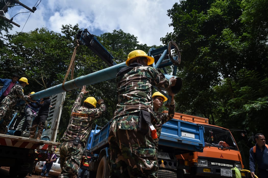 Technicians lift water pumps to the drilling site near Tham Luang cave, at the Khun Nam Nang Non Forest Park in Chiang Rai province on July 1, 2018 as the rescue operation continues for a missing children's football team and their coach.