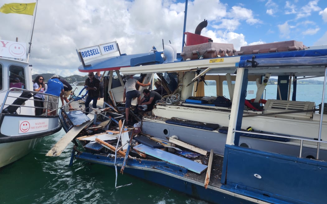 Passengers on the stricken Waitere are helped onto another ferry on 13 April 2023. The damaged vessel sank about an hour later.
