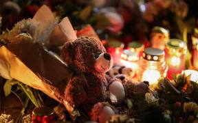 A teddy bear lies at a makeshift memorial near the site of a car-ramming attack on a Christmas market in Magdeburg, eastern Germany, on December 21, 2024. - The death toll in the attack on December 20, rose to 5 on December 21, 2024, with over 200 injured, according to the head of the regional government, Reiner Haseloff. (Photo by Ronny HARTMANN / AFP)