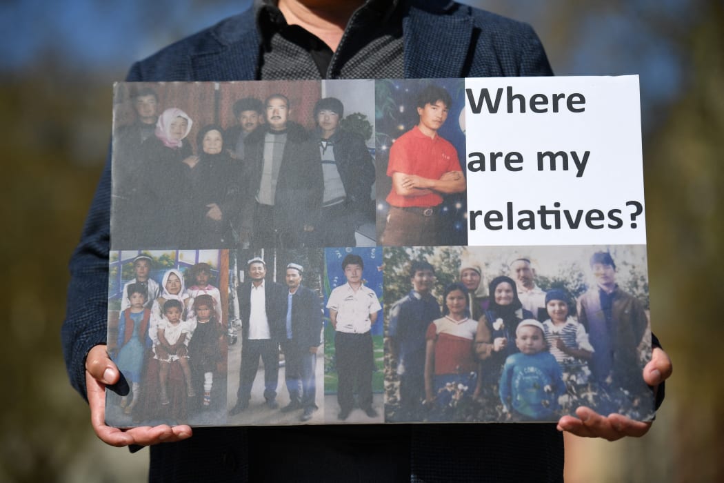 A member of the Uyghur community holds a placard as he joins a demonstration to call on the British parliament to vote to recognise alleged persecution of the Uyghur people as genocide and crimes against humanity in London on April 22, 2021.