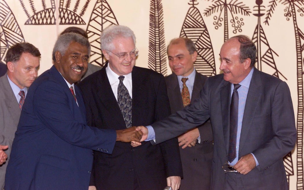 French Prime Minister Lionel Jospin (C) watches with Roch Wamytan, president of the separatist Kanak Socialist National Liberation Front (FNLKS) (L) and Jacques Lafleur, president of the loyalist Rally for Caledonia in the Republic (RCPR), after the signature of their historic accord in Noumea.
