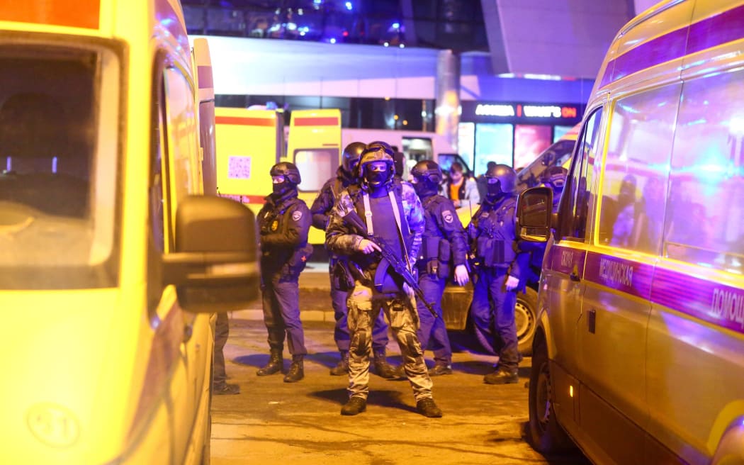 Medics and law enforcement officers are seen outside the Crocus City Hall concert hall following a shooting incident in Krasnogorsk, outside Moscow, on 22 March, 2024.