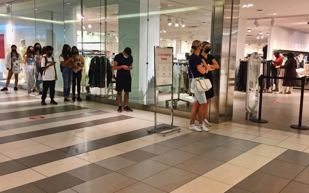 People wait to enter a store in a shopping mall as stores limit the number of customers allowed inside during the novel coronavirus (COVID-19) pandemic in Toronto, Ontario, Canada on July 03, 2021. Ontario is now in the second stage of the 3 stage reopening plan.