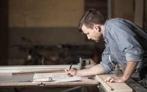 Carpenter looking at the plans, joiner, small business