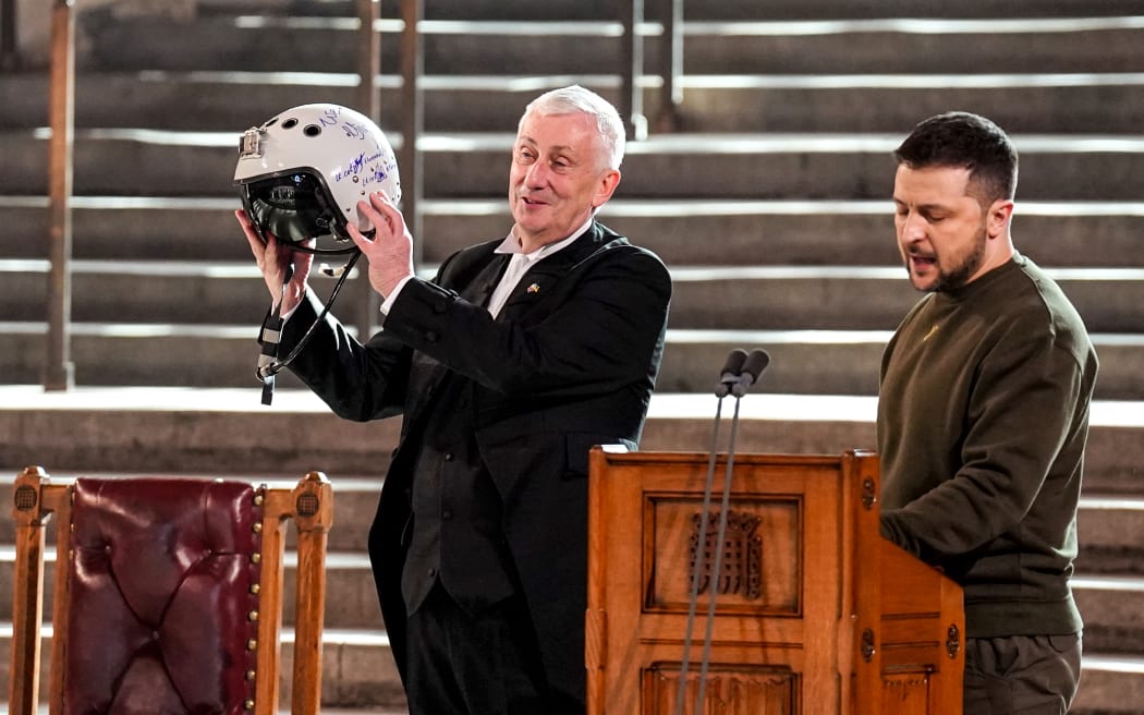 Speaker of the House of Commons, Sir Lindsay Hoyle, left, holds the helmet of one of the most successful Ukrainian pilots, inscribed with the words "We have freedom, give us wings to protect it", which was presented to him by Ukraine's President Volodymyr Zelensky during his address to British MPs in Westminster Hall, on February 8, 2023.
