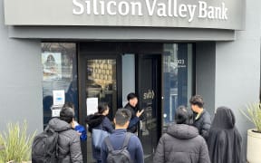 A worker (centre) tells people that the Silicon Valley Bank (SVB) headquarters is closed on 10 March, 2023 in Santa Clara, California.