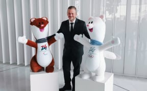 Andrew Parsons, President of the International Paralympic Committee, is seen with the mascots Tina and Milo during the press briefing for the Opening Ceremony and on the decision to allow athletes from Russia and Belarus to participate in the Games using their respective countries' flags, anthems, and uniforms during the XIV Winter Paralympic Games Milano Cortina 2026 at the Allianz Tower in Milan, Italy, on February 23, 2026 (Photo by Alessandro Bremec/NurPhoto). (Photo by Alessandro Bremec / NurPhoto via AFP)