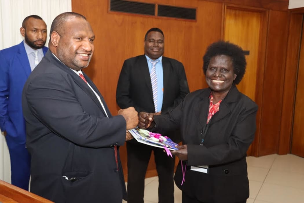 Papua New Guinea's Prime Minister James Marape receives a final report into the Bougainville Referendum from Ruby Miringka of the Bougainville Referendum Commission.