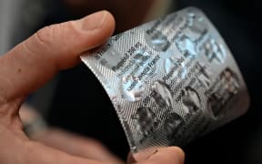 Medical staff shows on February 26, 2020 at the IHU Mediterranee Infection Institute in Marseille, a packet of Plaqueril, tablets containing hydroxychloroquine, drug that has shown signs of effectiveness against coronavirus.