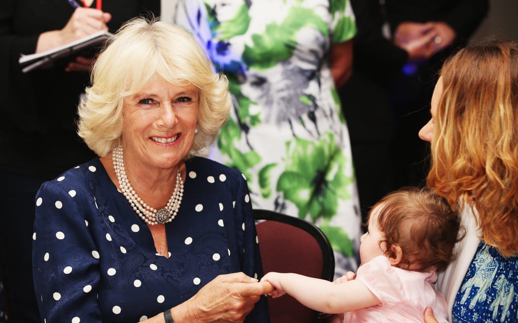 The Duchess of Cornwall interacts with a baby at Auckland charity Bellyfull
