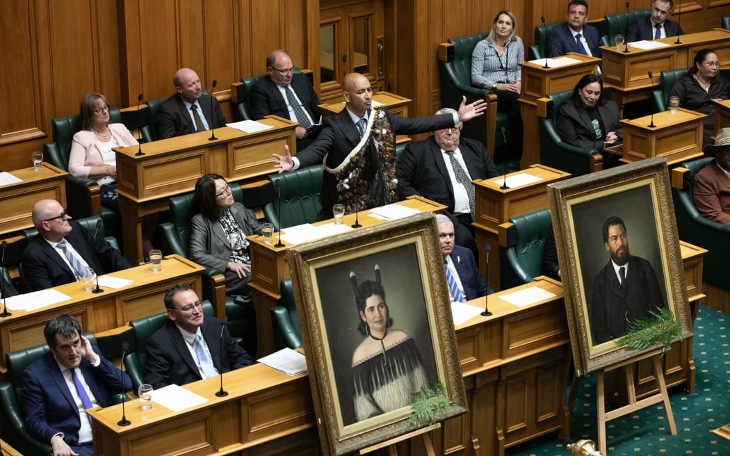 Hamilton West MP Tama Potaka delivers his maiden statement in Parliament with life-size portraits of his ancestors in the foreground, 7 March 2023.