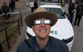 A member of New York State Park Police watches the partial Solar Eclipse on April 8, 2024 in Niagara Falls, New York.