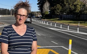 Aongatete resident Kirsten Warbrooke in front of the new median barrier causing frustration on State Highway 2 near Katikati.