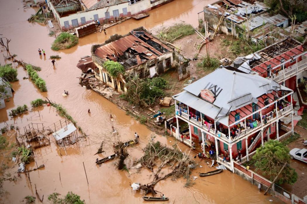 People walk on the flooded street of Buzi, central Mozambique, on March 20, 2019 after the passage of the cyclone Idai.