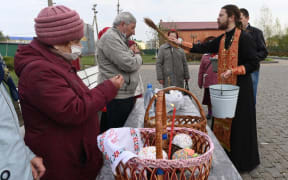 An orthodox priest blesses Easter cakes and eggs with holy water during Easter celebrations at Krasnodar region, Russia.  Sergey Pivovarov / Sputnik