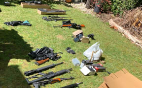 Dozens of firearms including a large number of prohibited military style semi-automatic firearms, a shotgun and a pistol were found in a search warrant.