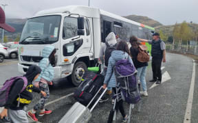 Buses are taking stranded Queenstown Airport passengers stranded by a bomb alert to the Queenstown Event Centre to provide shelter from the rain and food.