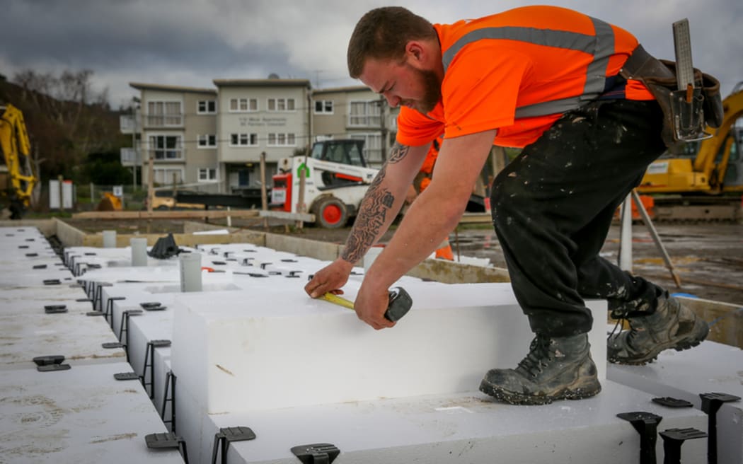 A builder installing polystyrene used for insulation and foundation footings on a new home in Upper Hutt.