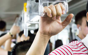 Passengers holding on crowded public transport.
