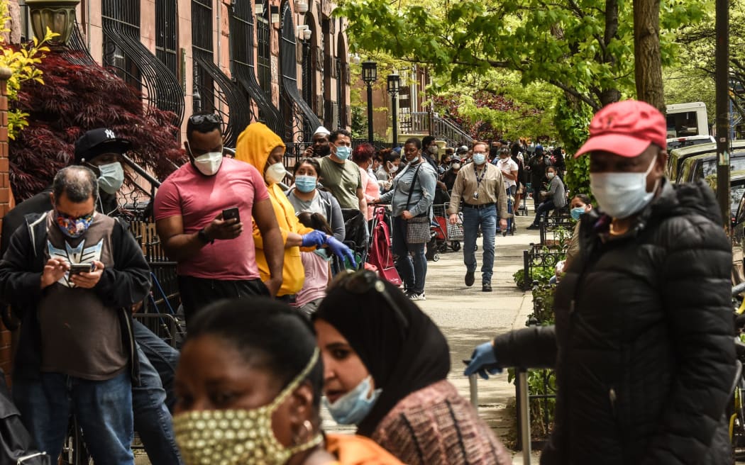 NEW YORK, NY - MAY 15: People wait on a long line to receive a food bank donation at the Barclays Center on May 15, 2020 in the Brooklyn borough in New York City.