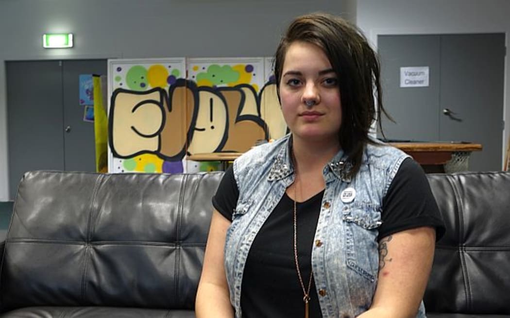 Youth worker, Kassie Hartendorp, sits on black couch at drop in centre