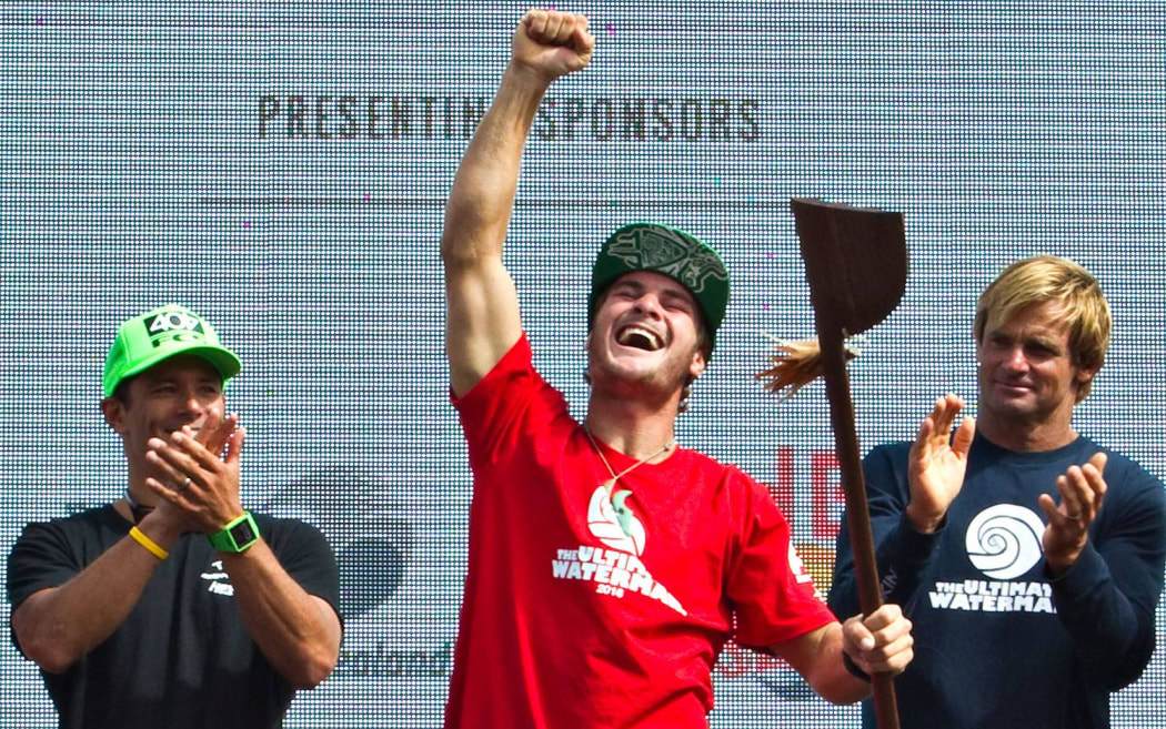 Zane Schweitzer displays the trophy presented by Laird Hamilton (right)