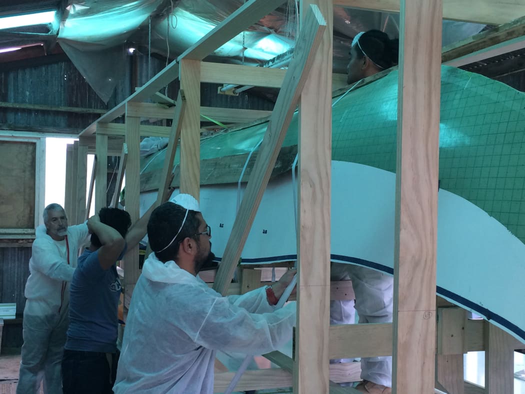 The team works on the canoe.