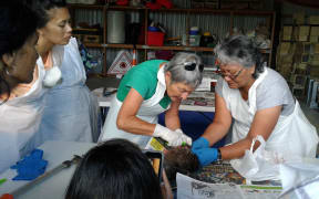Hapu members at a workshop in Northland watch as a dead kiwi's pelt is removed.