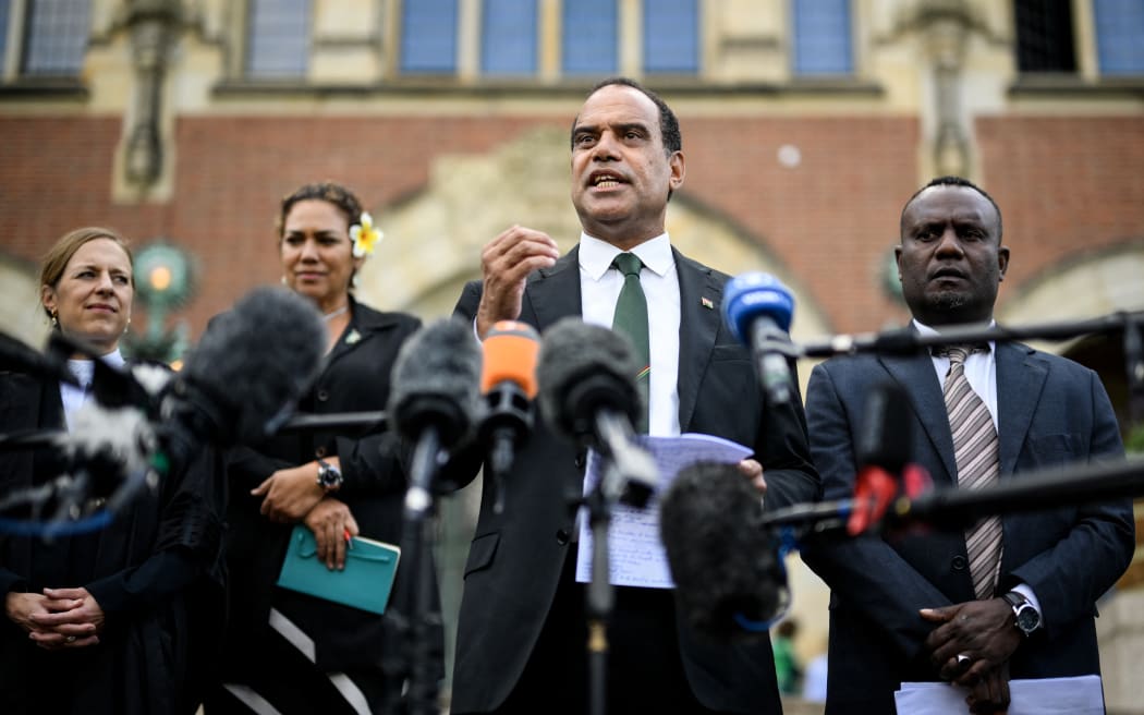 Vanuatu's Climate Change Minister Ralph Regenvanu (centre) speaks to the media 