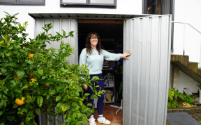 Image of a woman holding open a shed door