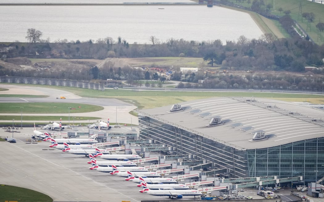 An aerial photograph taken on March 21, 2025 shows planes parked on the tarmac of Heathrow Airport following its closure after a fire broke out at a substation supplying power of the airport, in Hayes, west London. Britain's Heathrow airport, Europe's busiest, was shut down early on March 21 for 24 hours after a major fire at an electricity substation cut power to the sprawling facility west of London, officials said. (Photo by AFP)
