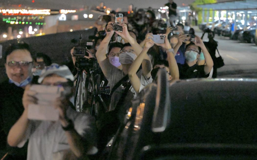 Onlookers take pictures as the plane of US House of Representatives Speaker Nancy Pelosi approches Sungshan Airport in Taipei  on 2 August, 2022.