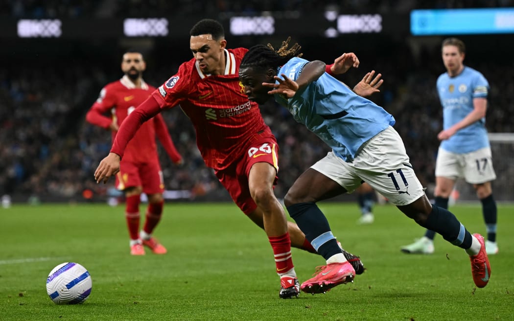 Liverpool's English defender Trent Alexander-Arnold, left, vies with Manchester City's Belgian midfielder Jeremy Doku during the English Premier League match at Etihad Stadium in Manchester, Feb 23, 2025.