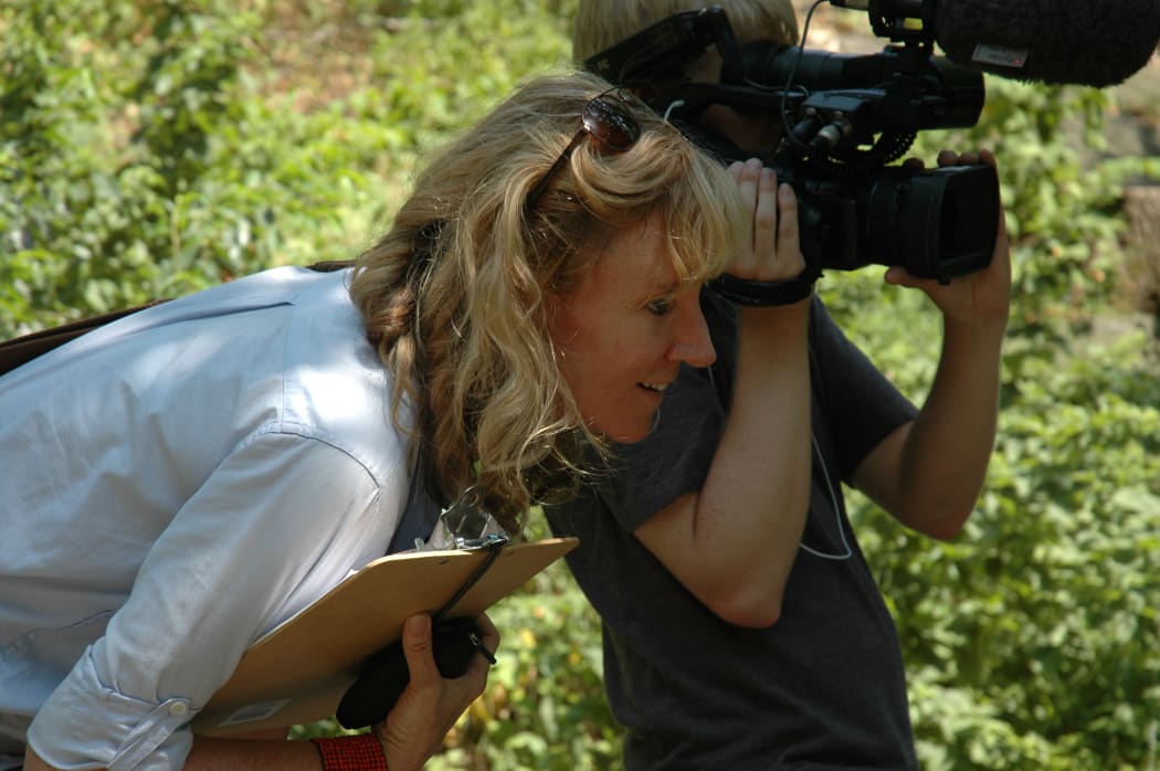 Director Producer Lilibet Foster on set, with a clipboard in hand