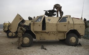 German troops work on a military vehicle at the NATO military base Camp Marmal on the outskirts of Mazar-i-Sharif on 27 November, 2019.