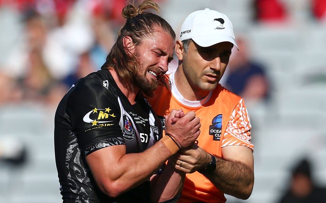 Kieran Foran leaves the filed with a dislocated shoulder in the test against Great Britain.
