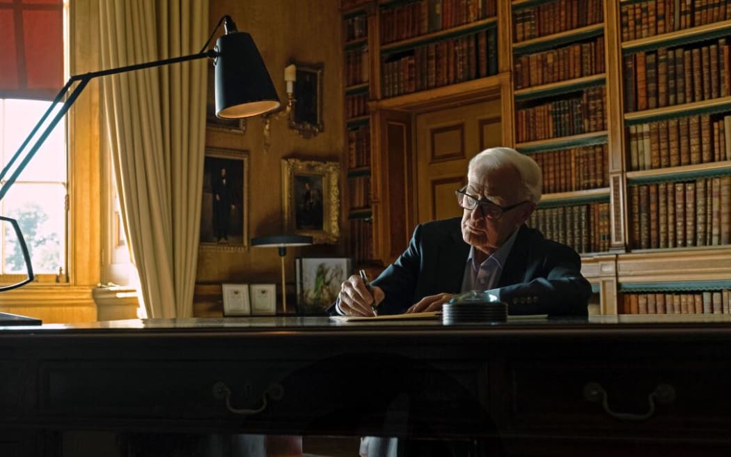 Movie still from the documentary film The Pigeon Tunnel showing the author John Le Carré at a writing desk