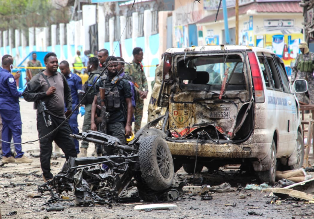 Security officers patrol on the site of a car-bomb attack in Mogadishu on 25 September 2021.