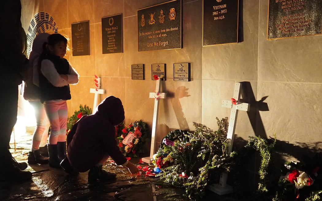 Children lay poppies at Kerikeri's Memorial Wall. Photo: RNZ/Peter de Graaf
