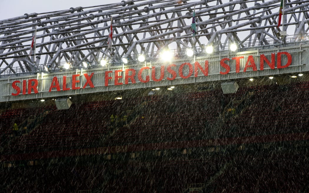 Light snow falling over the Sir Alex Ferguson stand at Old Trafford.