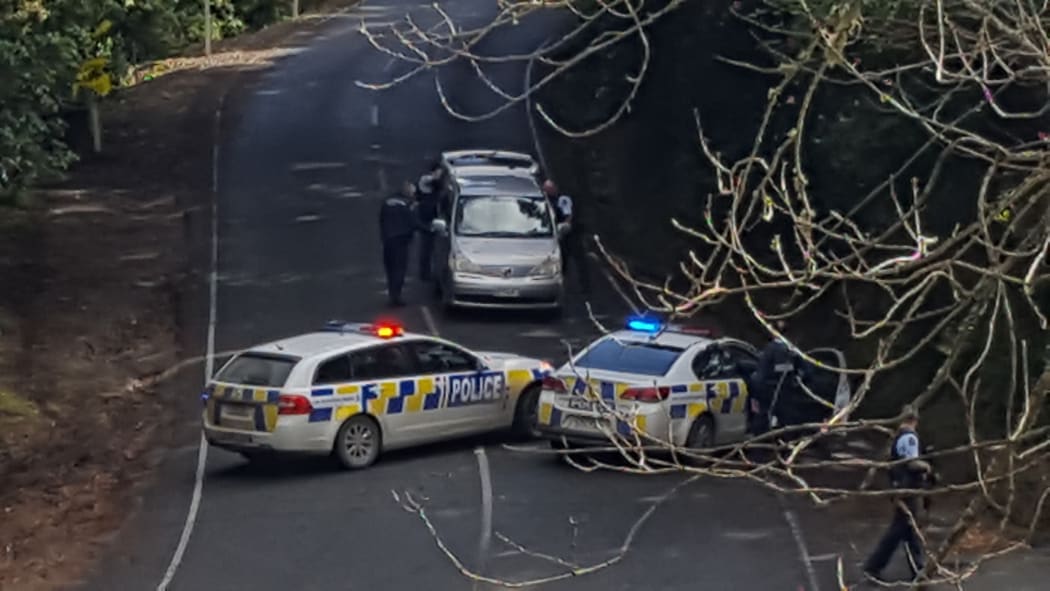 Police check cars at Owhiwa Rd / Whangarei Heads Rd cordon.