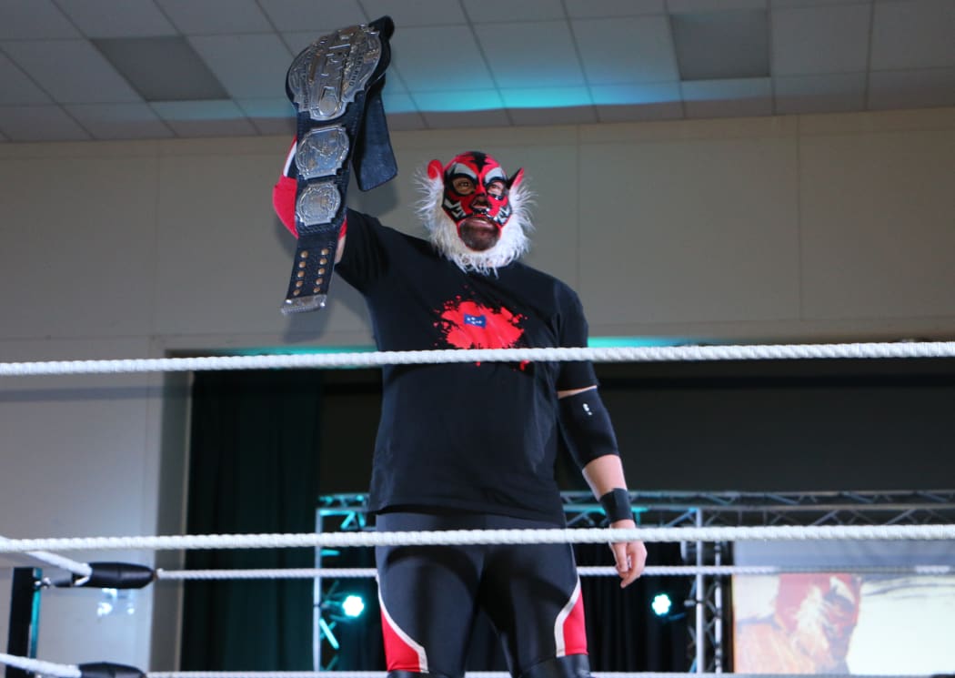 Liger/Michel Mulipola holds up his NZ Pro-Wrestling Championship belt.