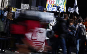 Supporters of WikiLeaks founder Julian Assange hold banners and placards as they protest in support of him, outside The Royal Courts of Justice, Britain's High Court, in central London  on May 20, 2024. WikiLeaks founder Julian Assange could find out on Monday whether he has won a reprieve in his last-ditch UK legal battle to avoid extradition to the United States. (Photo by BENJAMIN CREMEL / AFP)