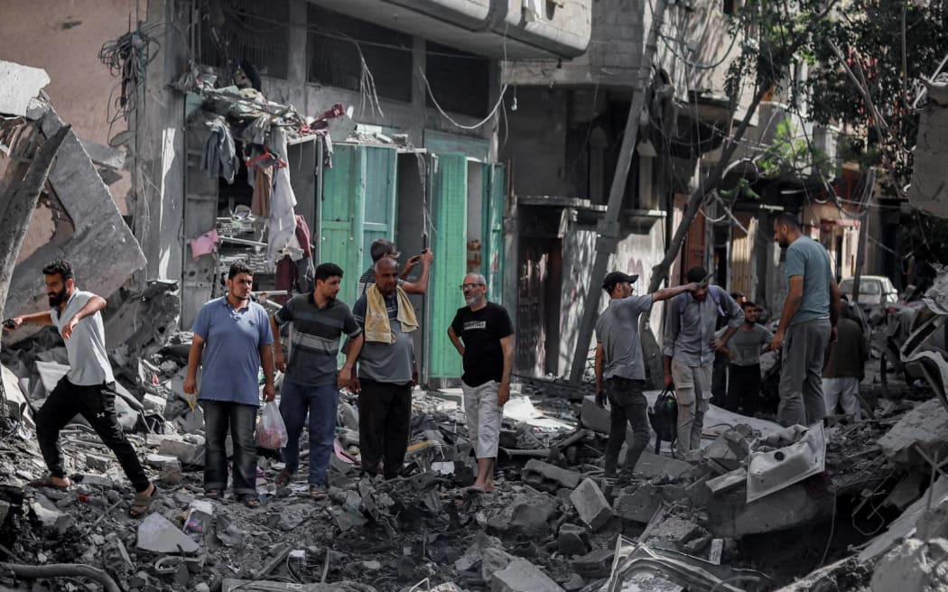 Palestinians check the rubble after the Israeli army withdrew from Nusairat in Gaza on June 8, 2024. The eight-month-long war of Israel in Gaza has devastated neighborhoods into rubles during the clashes with Hamas fighters. According to the United Nations and humanitarian agencies, nearly 1.7 million Palestinians have been displaced from their homes. Despite the growing pressure on the Israeli government led by Benjamin Netanyahu to accept the proposed truce and start a ceasefire, the Israeli war cabinet has insisted on going ahead with a more comprehensive military operation in the Gaza Strip. (Photo by Khames Alrefi / Middle East Images / Middle East Images via AFP)