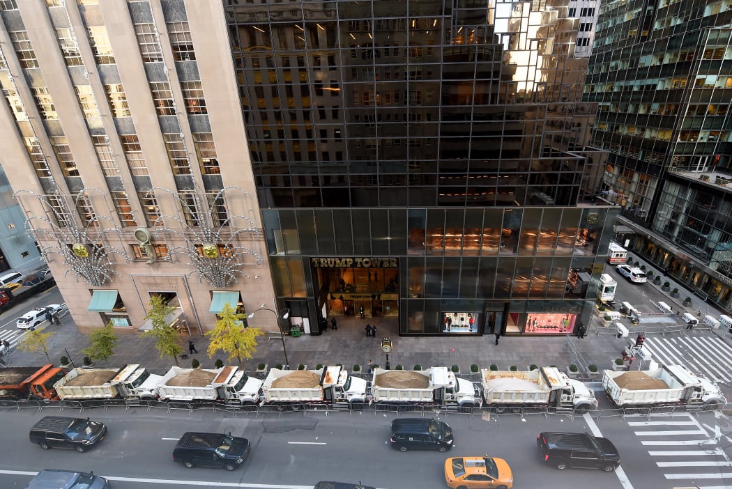 A protective barrier of sanitation department trucks parked in front of Trump Tower on 5th Avenue to provide security to President-elect Donald Trump.