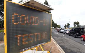 A long queue of cars wait at a drive-through COVID-19 testing site located in a shopping centre carpark in Melbourne.