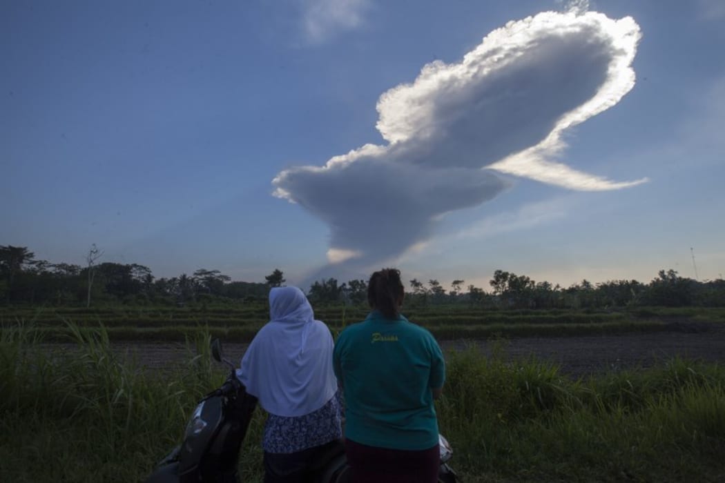 The villagers watch the Mount Merapi volcano erupt from the village of Donoharjo, near the city of Yogyakarta, in Indonesia on May 10, 2018.