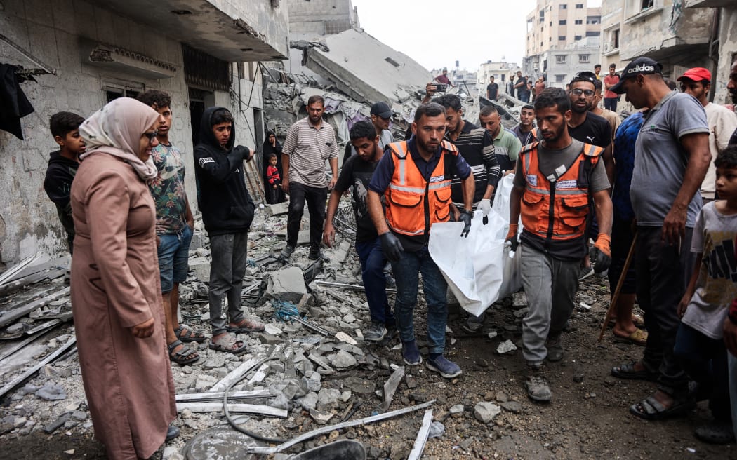 EDITORS NOTE: Graphic content / Palestinians carry bodies they recovered from the rubble of a house destroyed in an overnight Israeli strike in Gaza City on October 29, 2025. Gaza's civil defence agency said on October 29 that overnight air strikes killed at least 50 people in the Palestinian territory, as the Israeli military hit a string of targets after an attack that left a soldier dead. Israel began carrying out air strikes on October 28 after accusing Hamas of attacking Israeli troops in Gaza and violating the truce. (Photo by Omar AL-QATTAA / AFP)