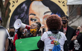A woman shouts through a megaphone during a protest memorial for Breonna Taylor in Jefferson Square Park, Louisville, Kentucky.